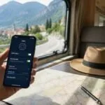 Smartphone con mappa e impostazioni eSIM appoggiato sul tavolo di un camper durante un viaggio all'estero.